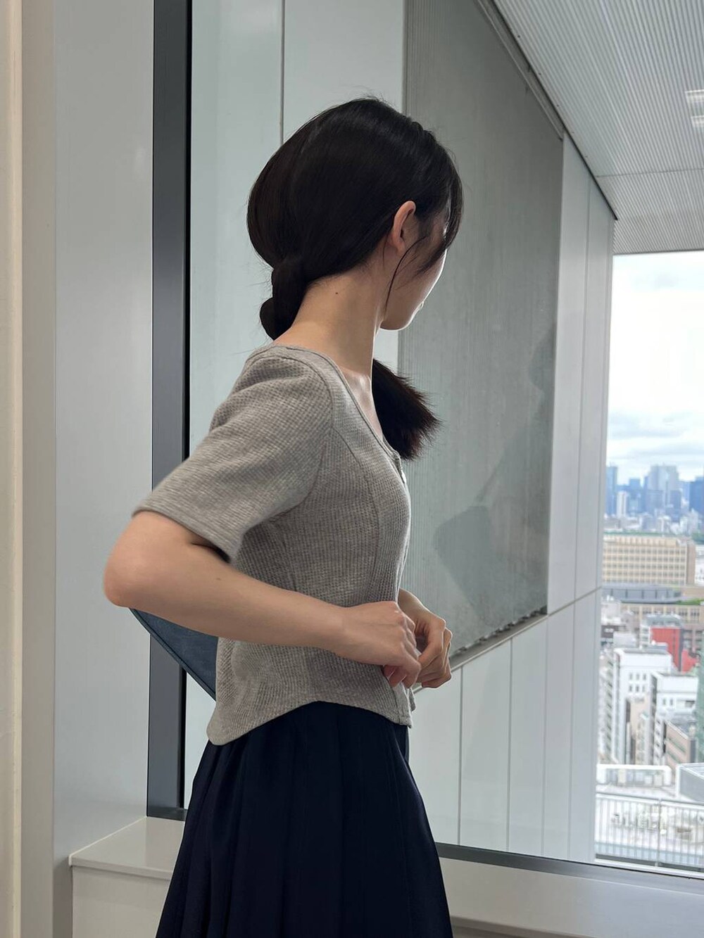 ブルー系のスカート、ブルー系のトートバッグ、グレー系のTシャツ/カットソーを着用したレディースの夏コーディネートの9枚目の写真