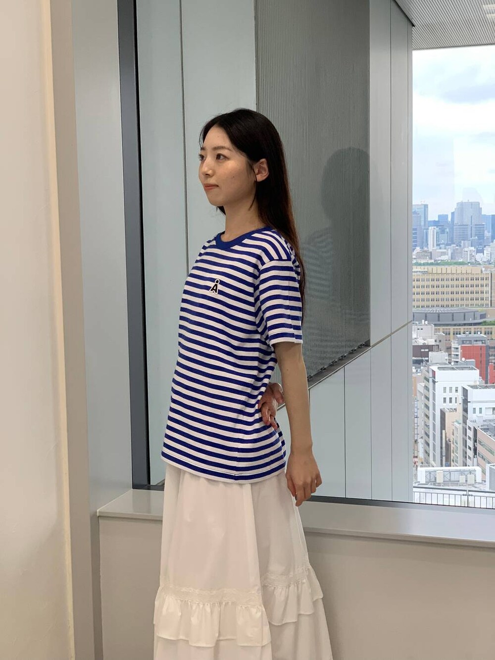 ホワイト系のスカート、ブルー系のTシャツ/カットソーを着用したレディースの夏コーディネートの4枚目の写真