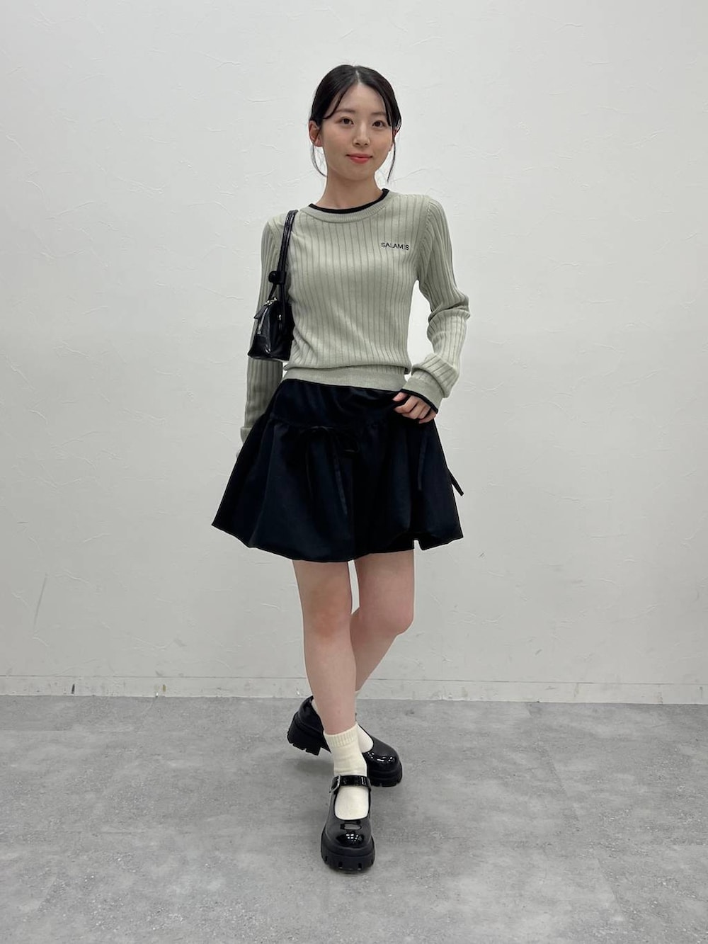 グレー系のTシャツ/カットソー、ブラック系のハンドバッグを着用したレディースの冬コーディネートの2枚目の写真