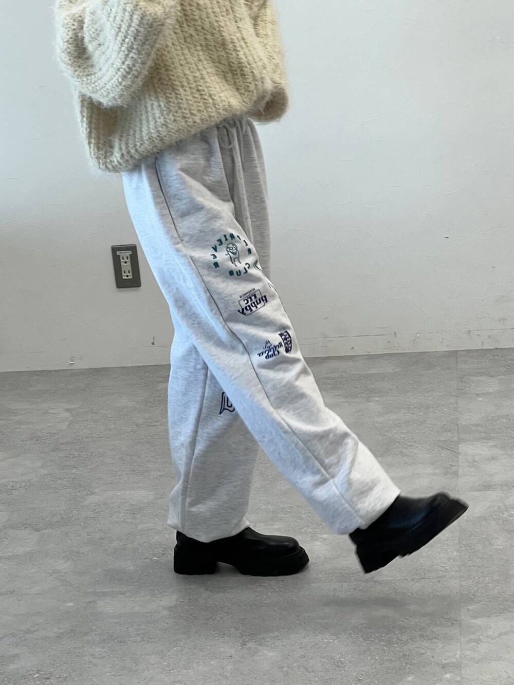 ブラック系のブーツ、ブラック系のショルダーバッグ、ベージュ系のニット/セーターを着用したレディースの冬コーディネートの7枚目の写真