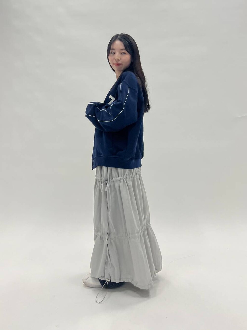 ホワイト系のTシャツ/カットソー、ブラック系のデニムパンツ、ブルー系のブルゾンを着用したレディースの冬コーディネートの3枚目の写真
