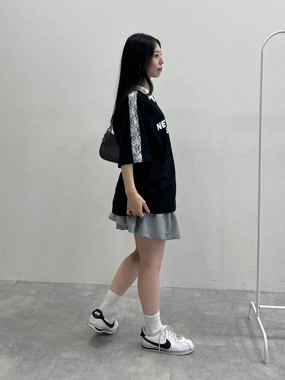 グレー系のスカート、ブラック系のトートバッグ、ブラック系のTシャツ/カットソーを着用したレディースの夏コーディネートの4枚目の写真