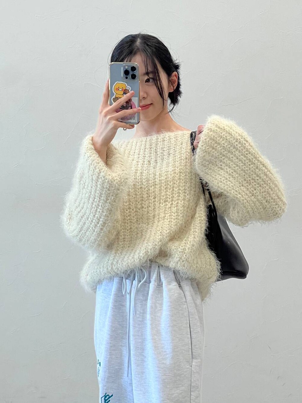 ブラック系のブーツ、ブラック系のショルダーバッグ、ベージュ系のニット/セーターを着用したレディースの冬コーディネートの9枚目の写真