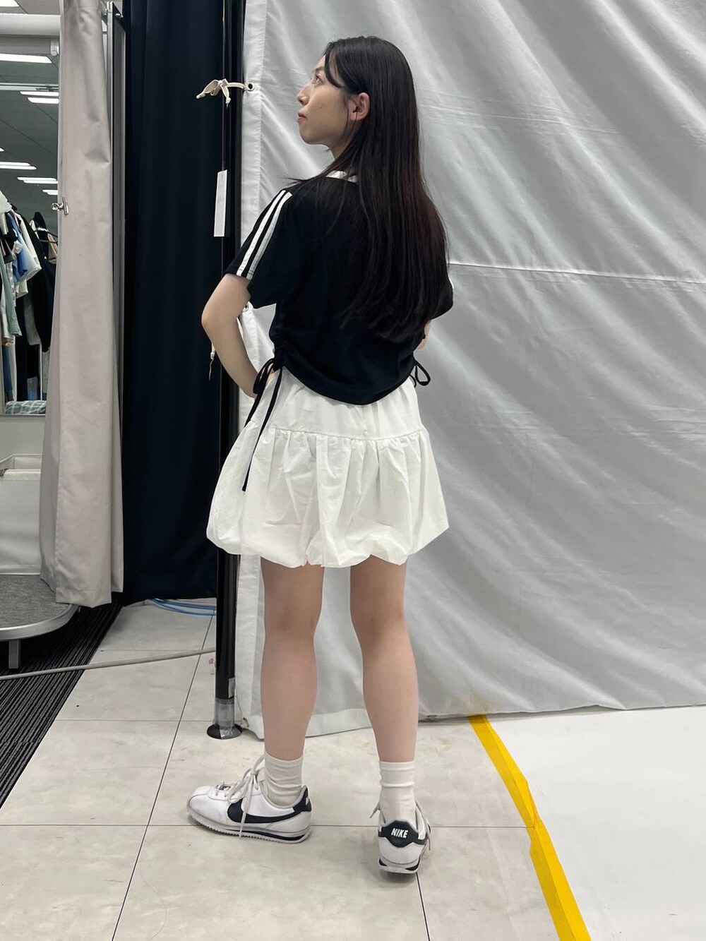 ホワイト系のスカート、ブラック系のTシャツ/カットソーを着用したレディースの夏コーディネートの3枚目の写真