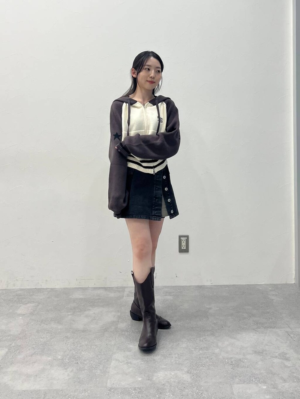 ブラウン系のスカート、ブラック系のデニムパンツを着用したレディースの春コーディネートの4枚目の写真