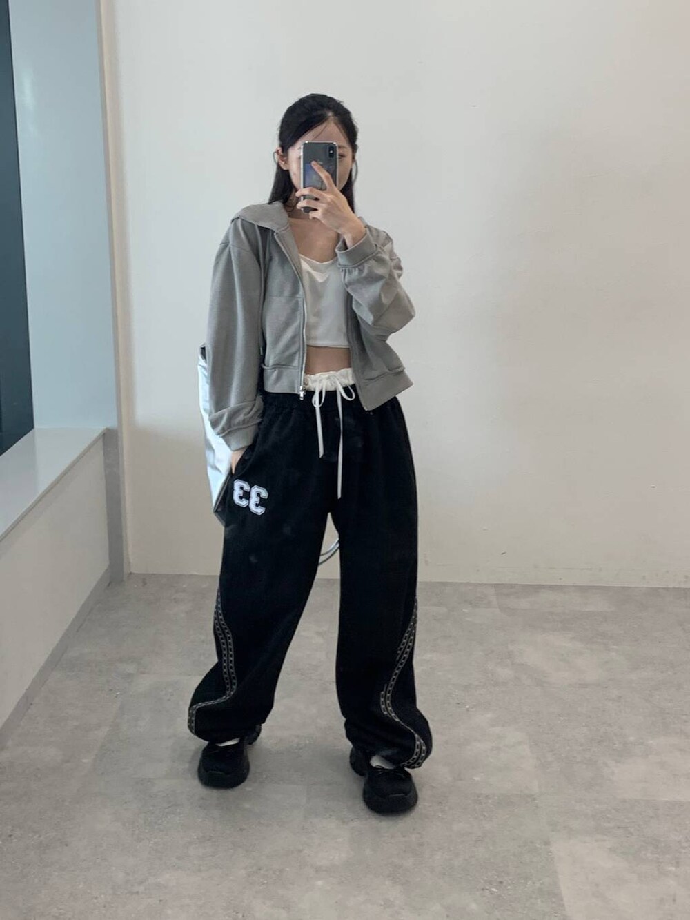 グレー系のパーカー、グレー系のバックパック/リュック、ブラック系のその他パンツを着用したレディースの秋コーディネートの4枚目の写真