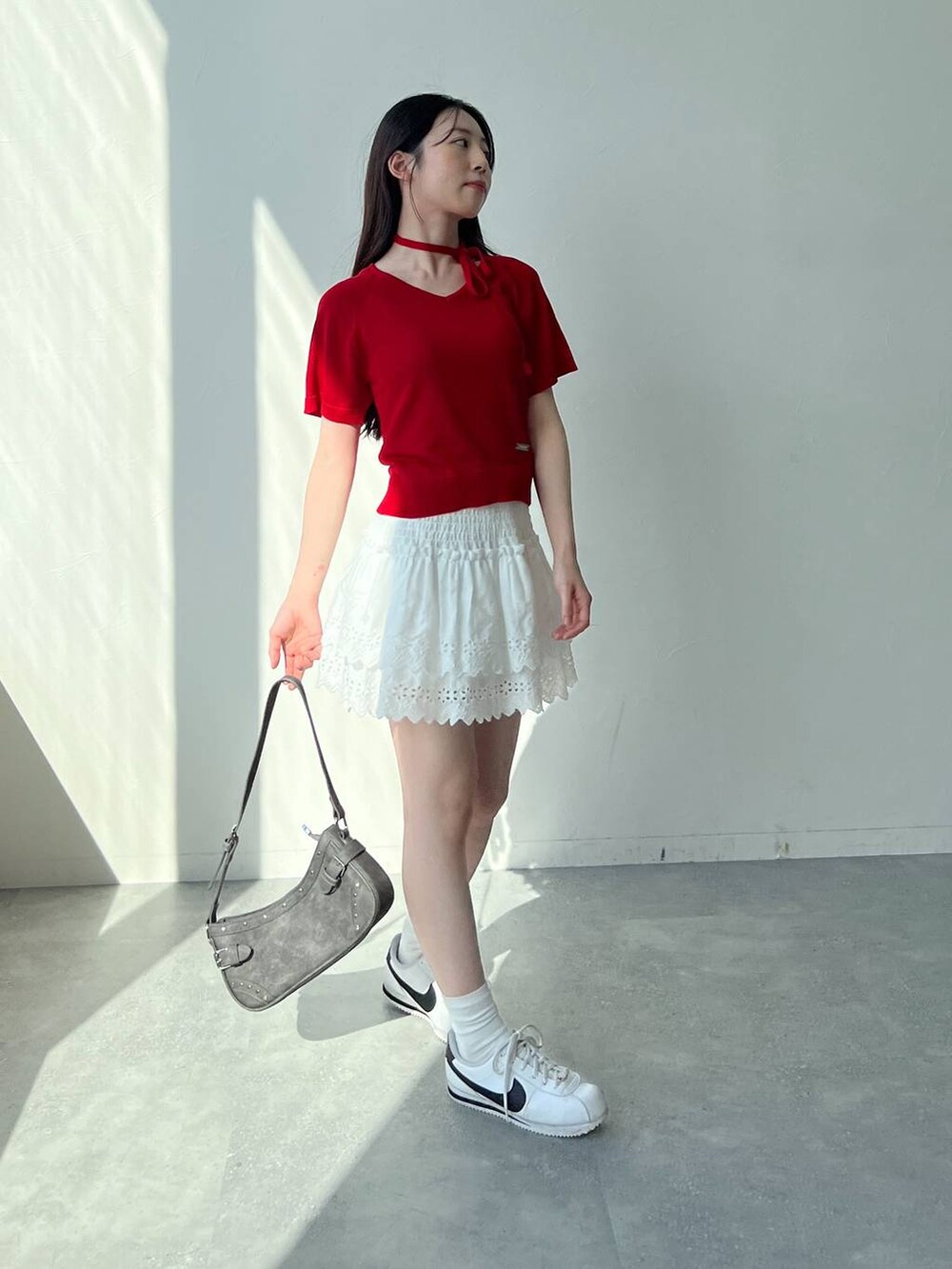 ホワイト系のスカート、ブラック系のトートバッグ、レッド系のニット/セーターを着用したレディースの夏コーディネートの5枚目の写真