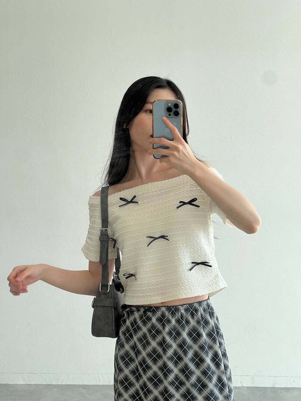 ホワイト系のTシャツ/カットソー、グレー系のスカート、ブラック系のトートバッグを着用したレディースの夏コーディネートの5枚目の写真