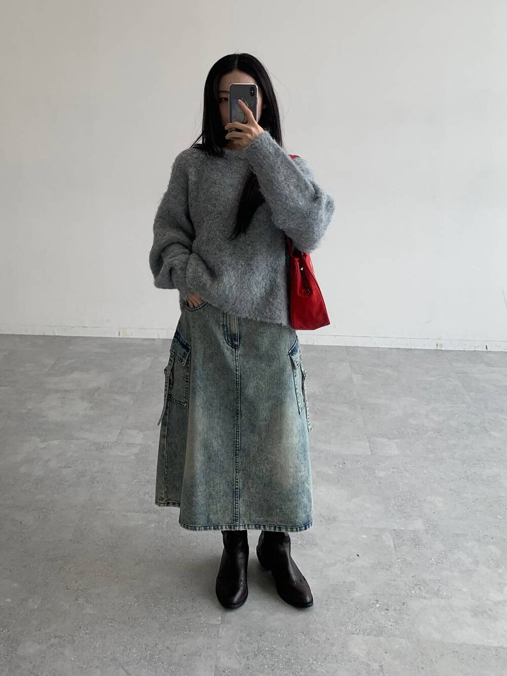 ブルー系のデニムスカート、グレー系のニット/セーターを着用したレディースの秋コーディネートの2枚目の写真