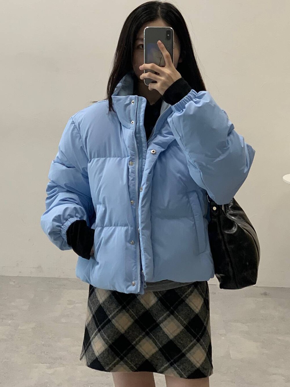 ブラック系のスカート、ブラック系のハンドバッグ、ブラック系のTシャツ/カットソーを着用したレディースの冬コーディネートの6枚目の写真