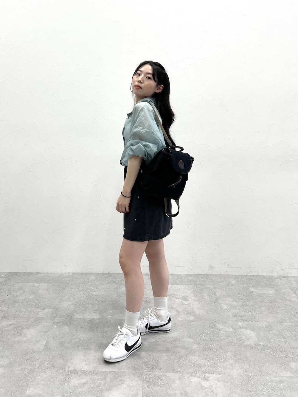 ブラック系のデニムスカート、ブルー系のシャツ/ブラウスを着用したレディースの春コーディネートの3枚目の写真