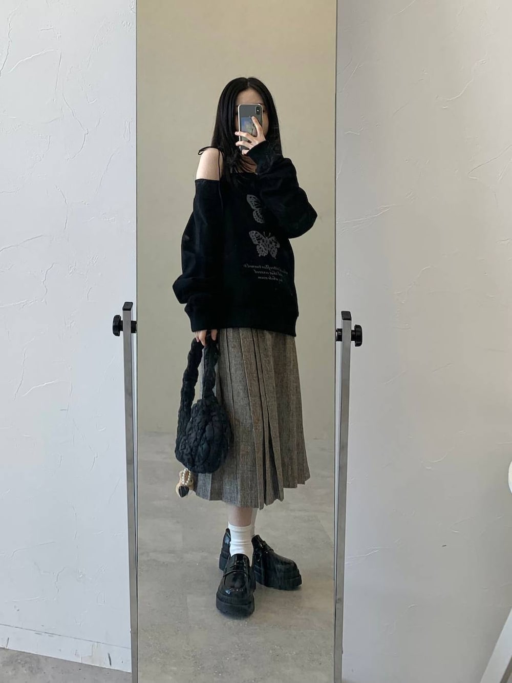 ブラック系のショルダーバッグ、ブラウン系のスカート、ブラック系のスウェットを着用したレディースの冬コーディネートの3枚目の写真