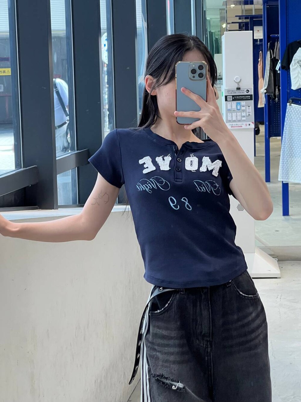 ブラック系のデニムパンツ、ブルー系のTシャツ/カットソー、ブラック系のベルトを着用したレディースの夏コーディネートの2枚目の写真