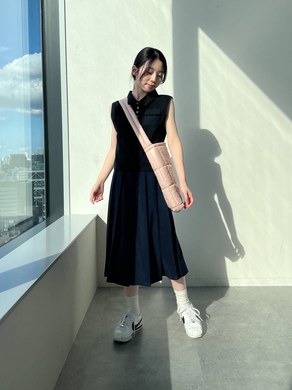 ブルー系のスカート、ピンク系のショルダーバッグ、ブラック系のタンクトップを着用したレディースの夏コーディネートの6枚目の写真