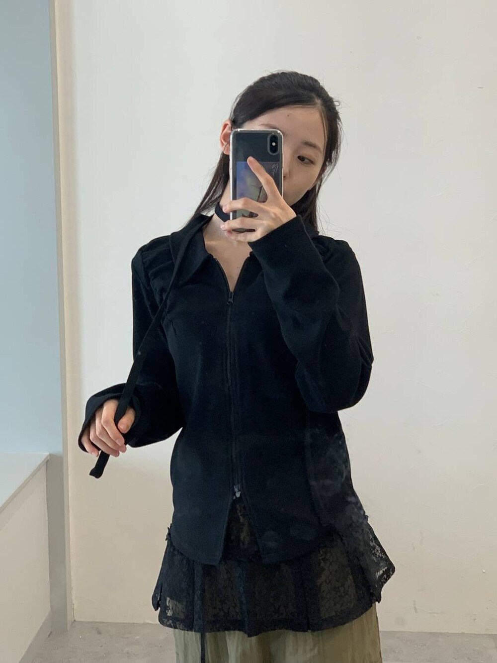 グリーン系のカーゴパンツ、ブラック系のスカート、ブラック系のTシャツ/カットソーを着用したレディースの秋コーディネートの4枚目の写真