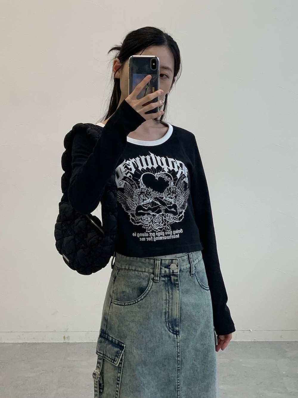 ブラック系のサンダル、ブラック系のショルダーバッグ、ブルー系のデニムスカートを着用したレディースの秋コーディネートの4枚目の写真