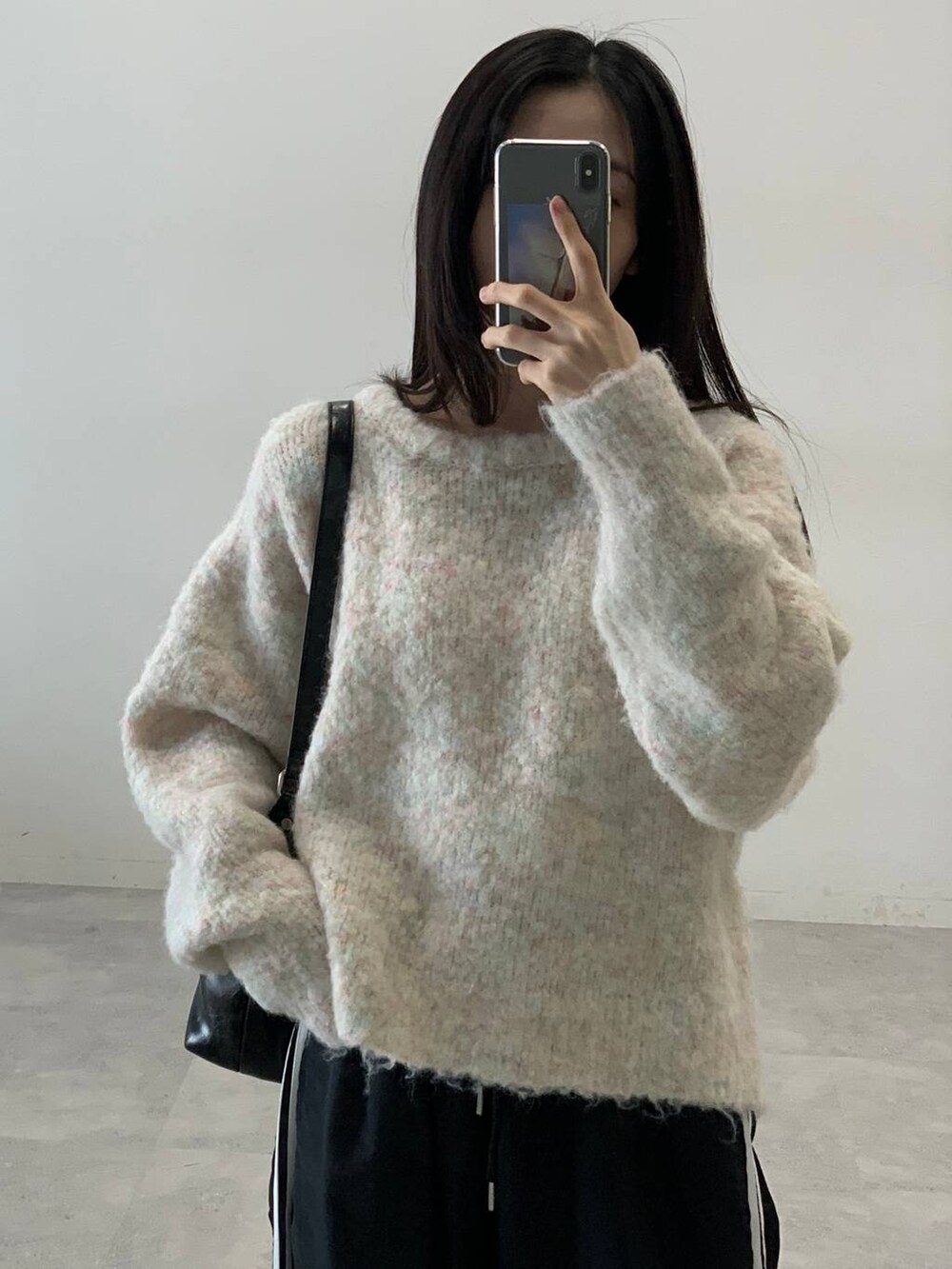 ブラック系のその他パンツ、ホワイト系のニット/セーター、ブラック系のハンドバッグを着用したレディースの秋コーディネートの7枚目の写真