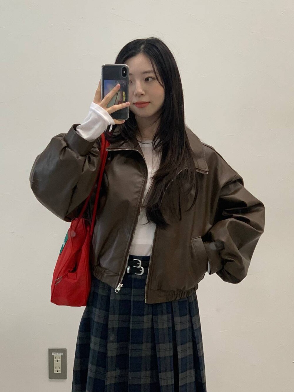 ブラック系のショルダーバッグ、ブラウン系のブルゾン、グレー系のスカートを着用したレディースの秋コーディネートの10枚目の写真