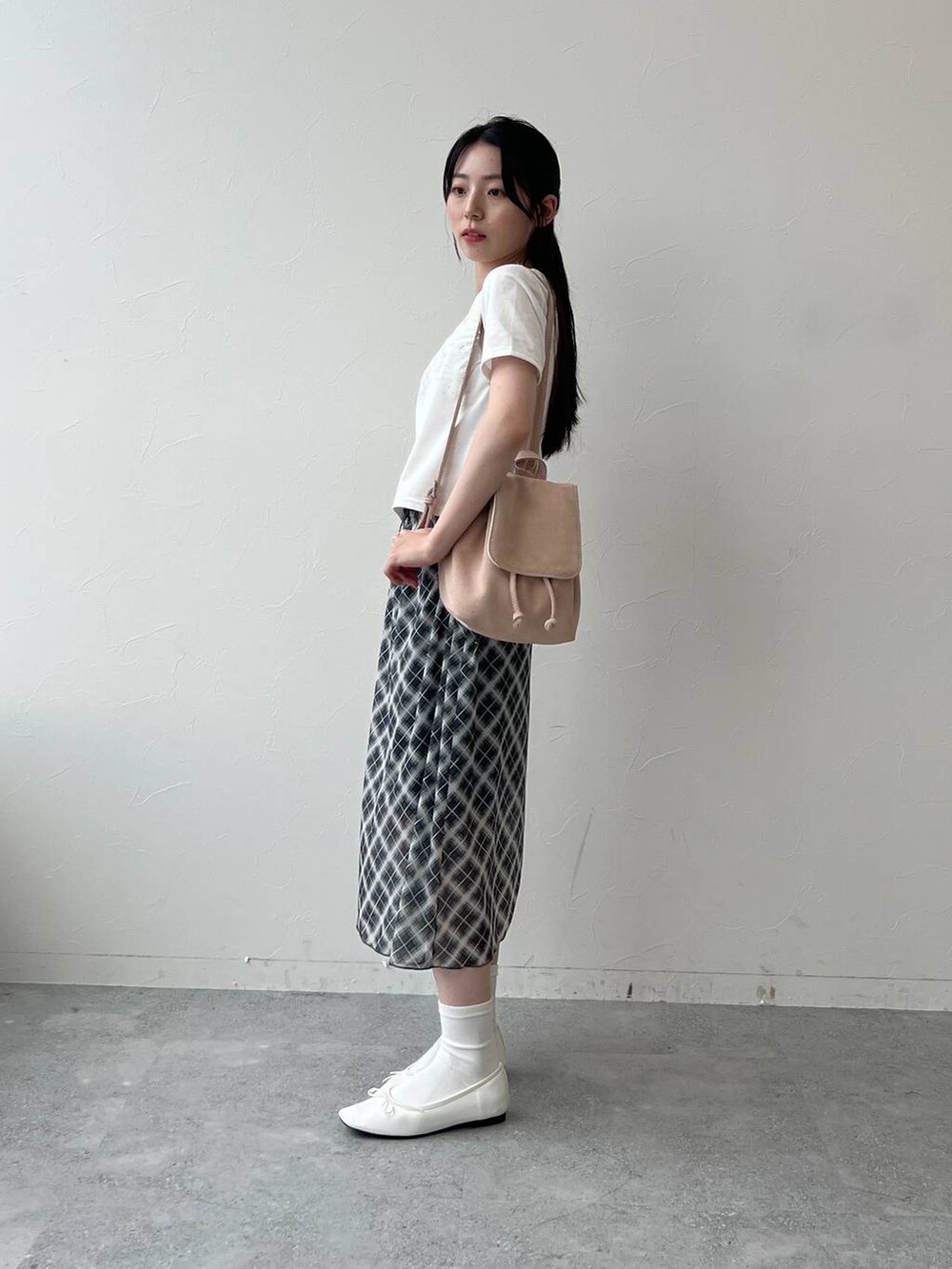 グレー系のスカート、ホワイト系のTシャツ/カットソーを着用したレディースの夏コーディネートの2枚目の写真