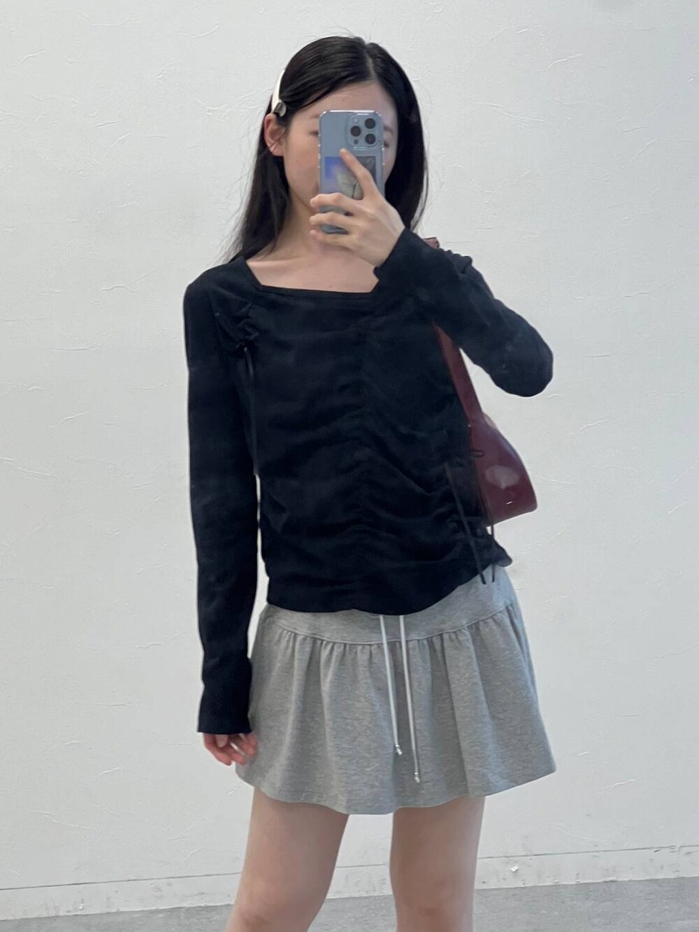 グレー系のスカート、ブラック系のTシャツ/カットソーを着用したレディースの夏コーディネートの5枚目の写真