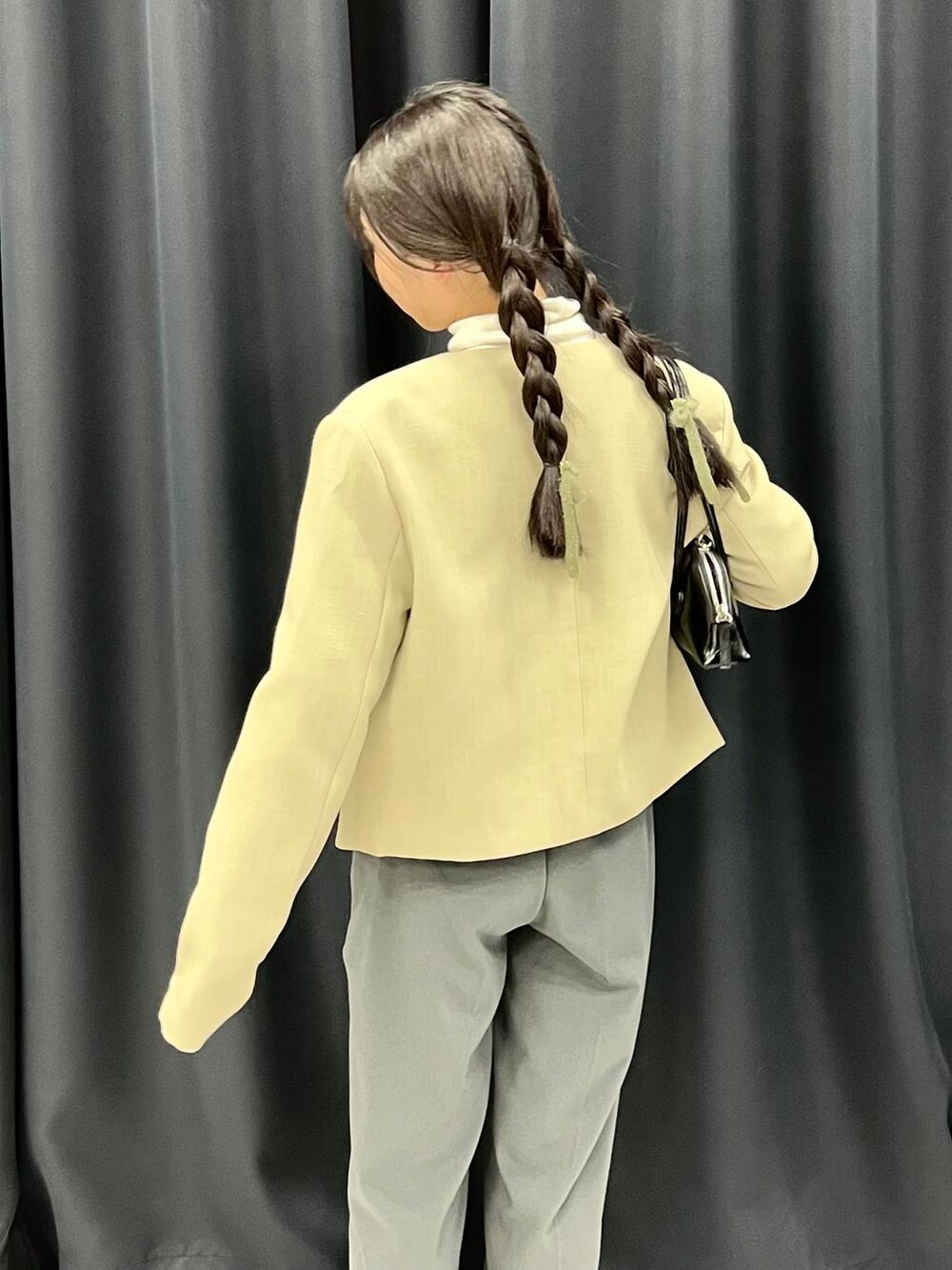 ベージュ系のTシャツ/カットソー、ベージュ系のノーカラージャケット、ピンク系のニット/セーターを着用したレディースの冬コーディネートの4枚目の写真