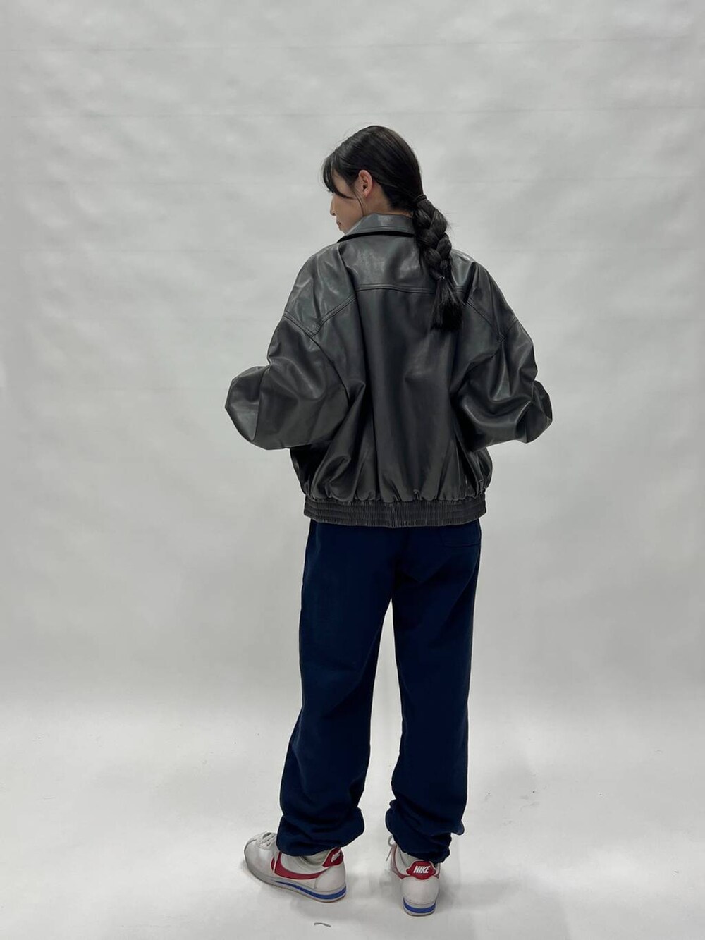 グレー系のブルゾン、ホワイト系のスニーカー、ブルー系のスウェットパンツを着用したレディースの冬コーディネートの4枚目の写真