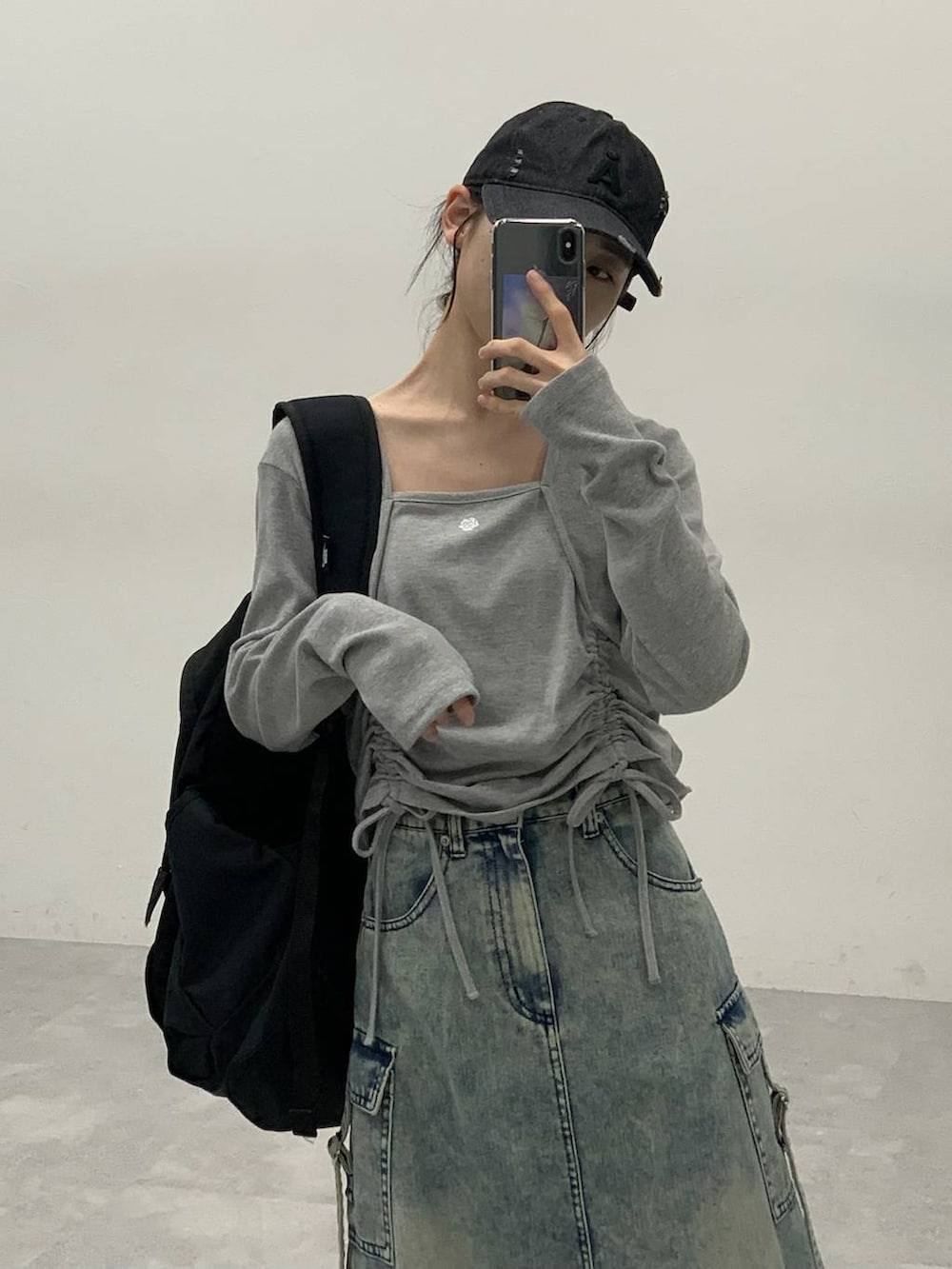 ブラック系のサンダル、ブルー系のデニムスカート、グレー系のTシャツ/カットソーを着用したレディースの秋コーディネートの4枚目の写真