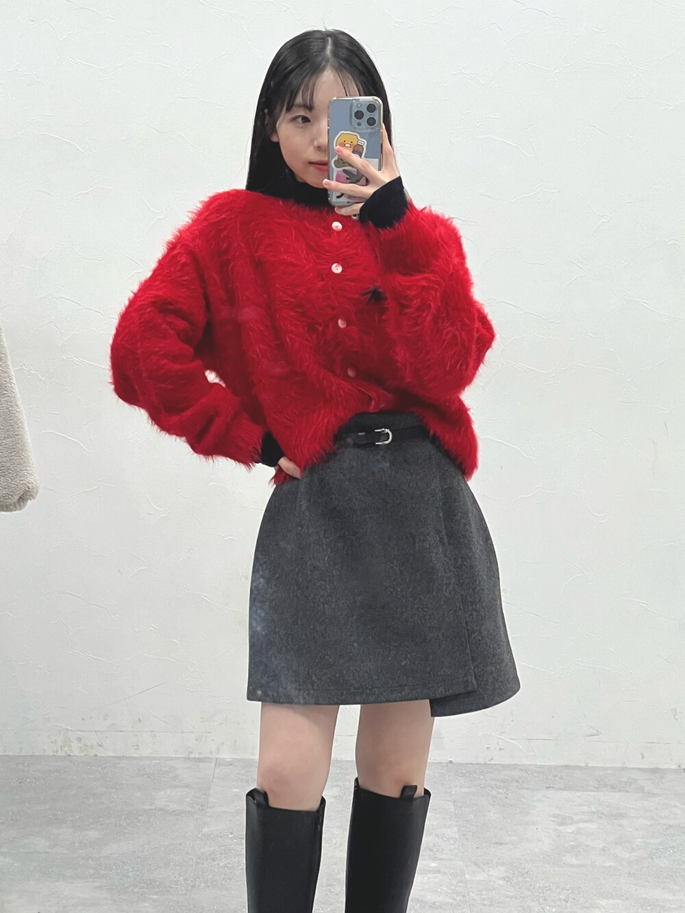 ブラック系のブーツ、グレー系のスカート、ベージュ系のTシャツ/カットソーを着用したレディースの冬コーディネートの4枚目の写真