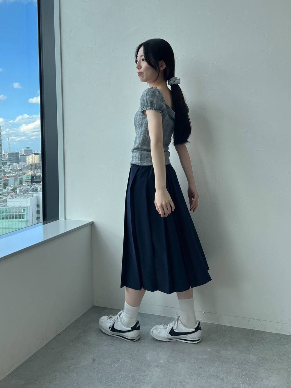 ブルー系のスカート、グレー系のTシャツ/カットソーを着用したレディースの夏コーディネートの4枚目の写真