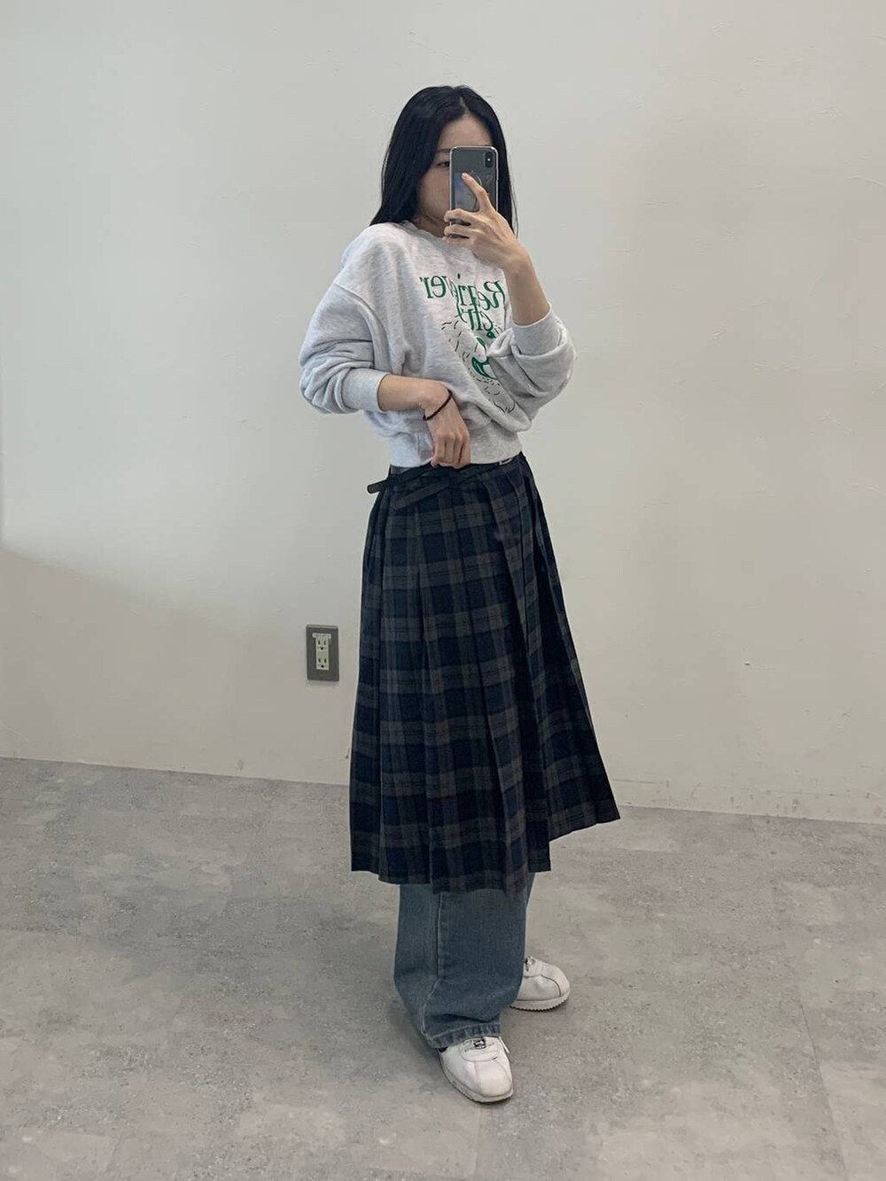 グレー系のスカート、グリーン系のスウェットを着用したレディースの秋コーディネートの3枚目の写真