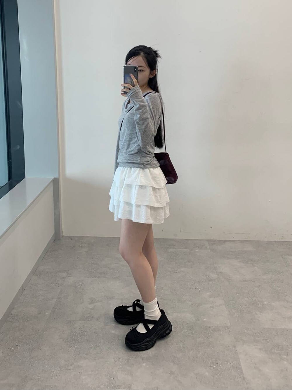 ホワイト系のスカート、グレー系のTシャツ/カットソーを着用したレディースの秋コーディネートの3枚目の写真