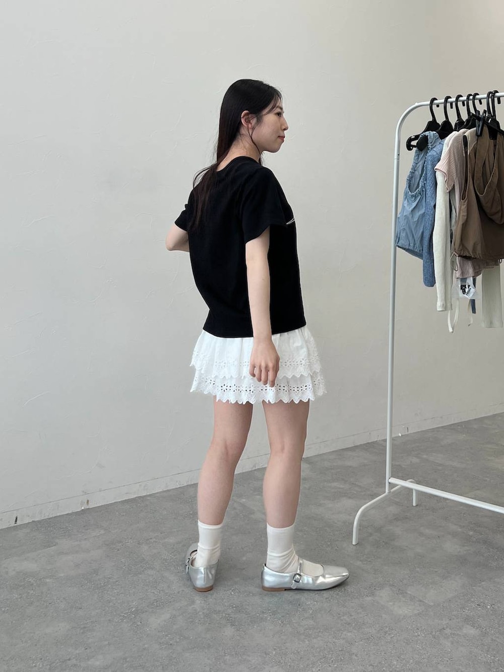 ホワイト系のスカート、ブラック系のTシャツ/カットソーを着用したレディースの夏コーディネートの3枚目の写真