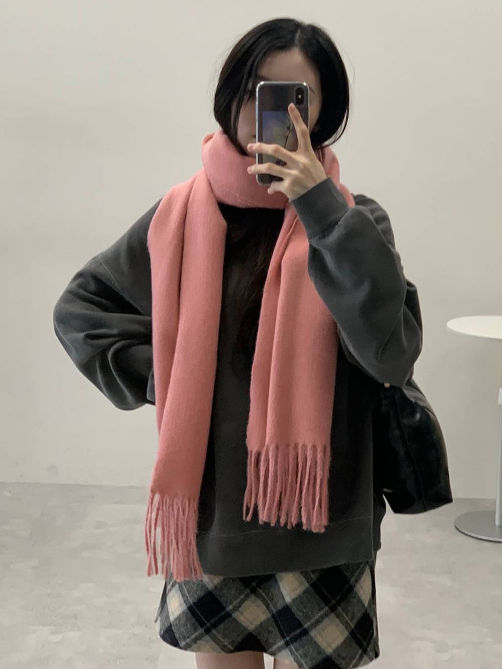 ブラック系のスカート、ブラック系のハンドバッグ、グレー系のスウェットを着用したレディースの冬コーディネートの6枚目の写真