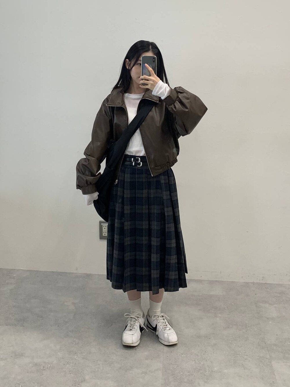 ブラック系のショルダーバッグ、ブラウン系のブルゾン、グレー系のスカートを着用したレディースの秋コーディネートの2枚目の写真