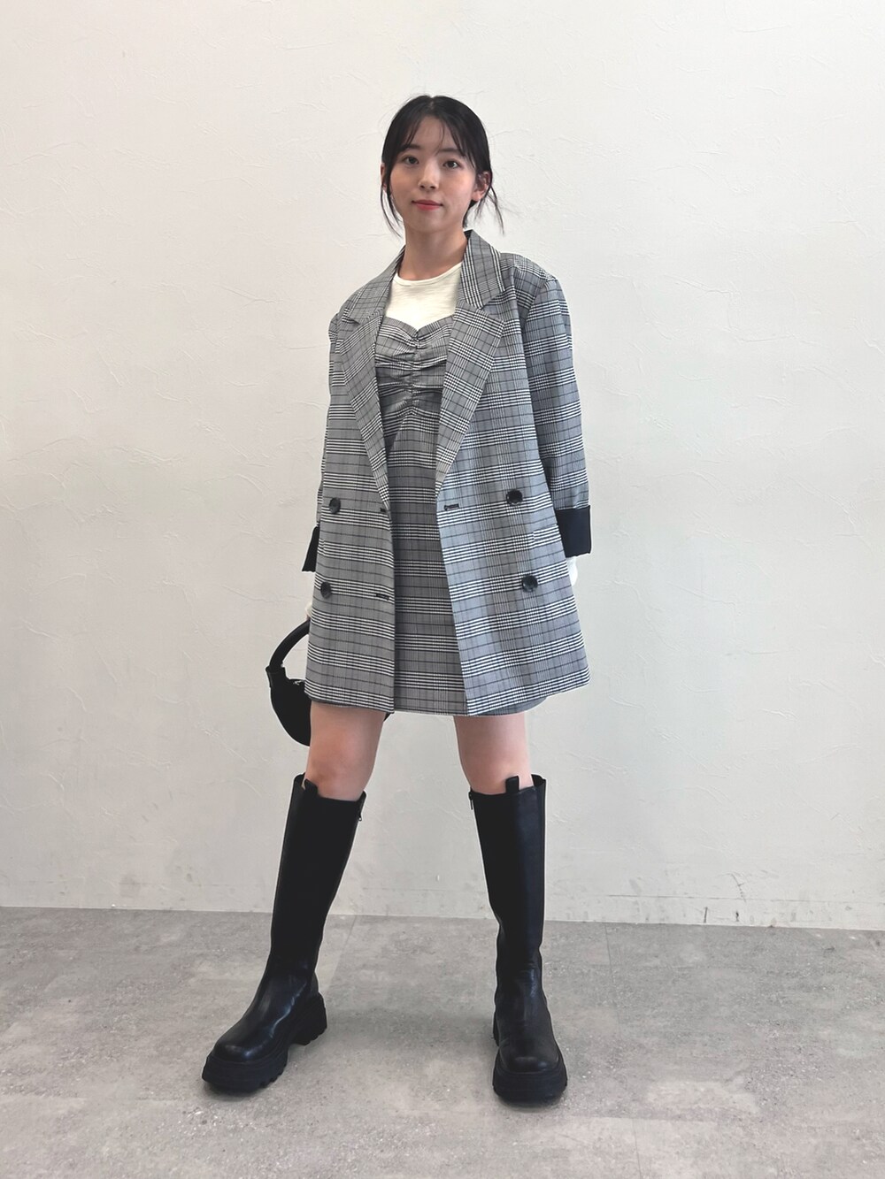 ブラック系のブーツ、ブラック系のショルダーバッグ、グレー系のスカートを着用したレディースの秋コーディネートの5枚目の写真