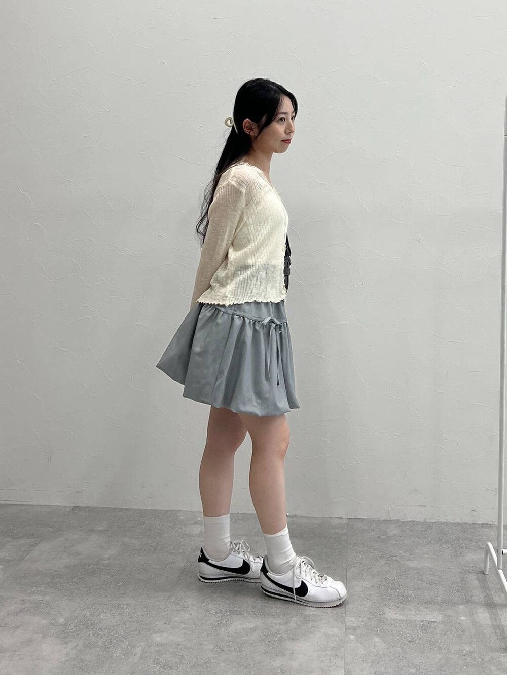 グレー系のスカート、ブラック系のトートバッグ、ベージュ系のカーディガン/ボレロを着用したレディースの夏コーディネートの4枚目の写真