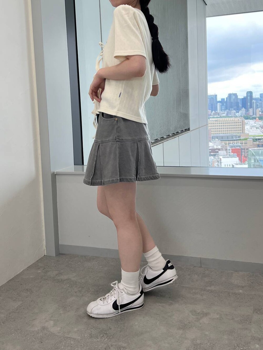 ベージュ系のカーディガン/ボレロ、グレー系のデニムスカートを着用したレディースの夏コーディネートの2枚目の写真
