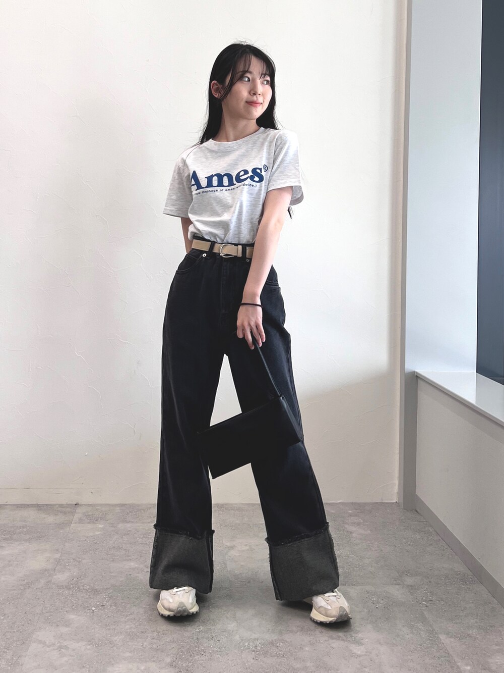 ブラック系のデニムパンツ、ホワイト系のスニーカー、グレー系のTシャツ/カットソーを着用したレディースの夏コーディネートの2枚目の写真