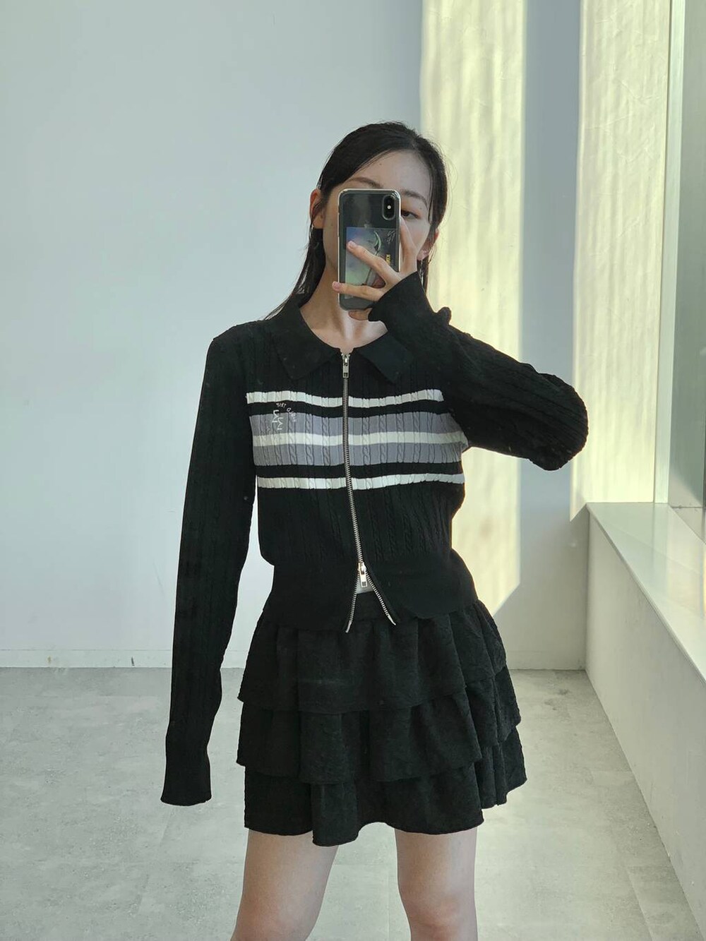 ブラック系のスカート、ブラック系のカーディガン/ボレロを着用したレディースの秋コーディネートの4枚目の写真