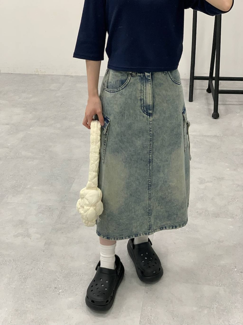 ブルー系のデニムスカート、ホワイト系のショルダーバッグ、ブルー系のTシャツ/カットソーを着用したレディースの秋コーディネートの8枚目の写真