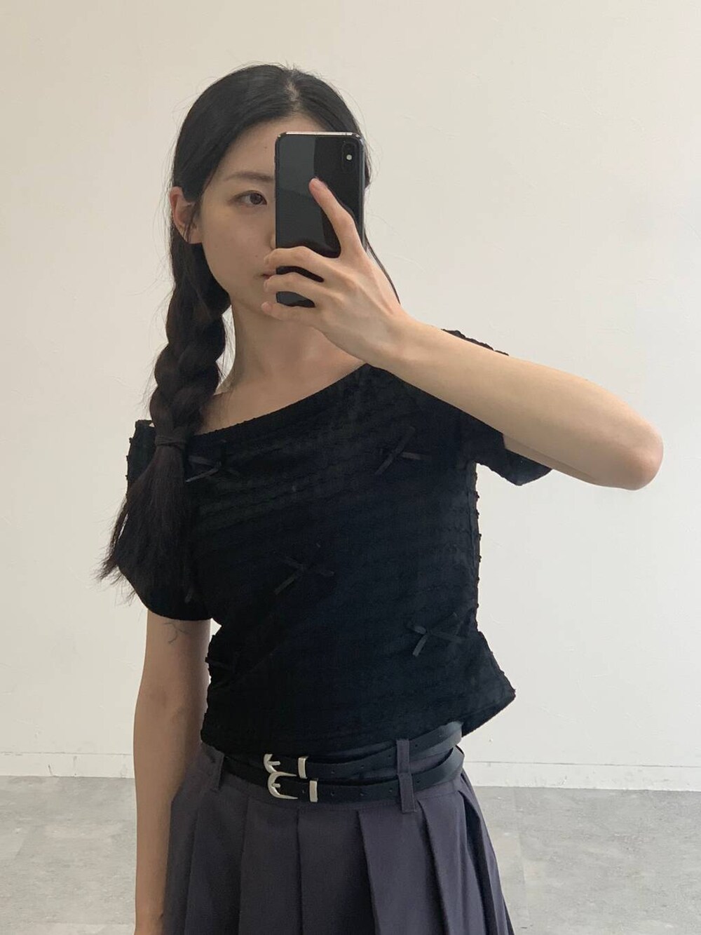 グレー系のスカート、ブラック系のTシャツ/カットソーを着用したレディースの夏コーディネートの4枚目の写真