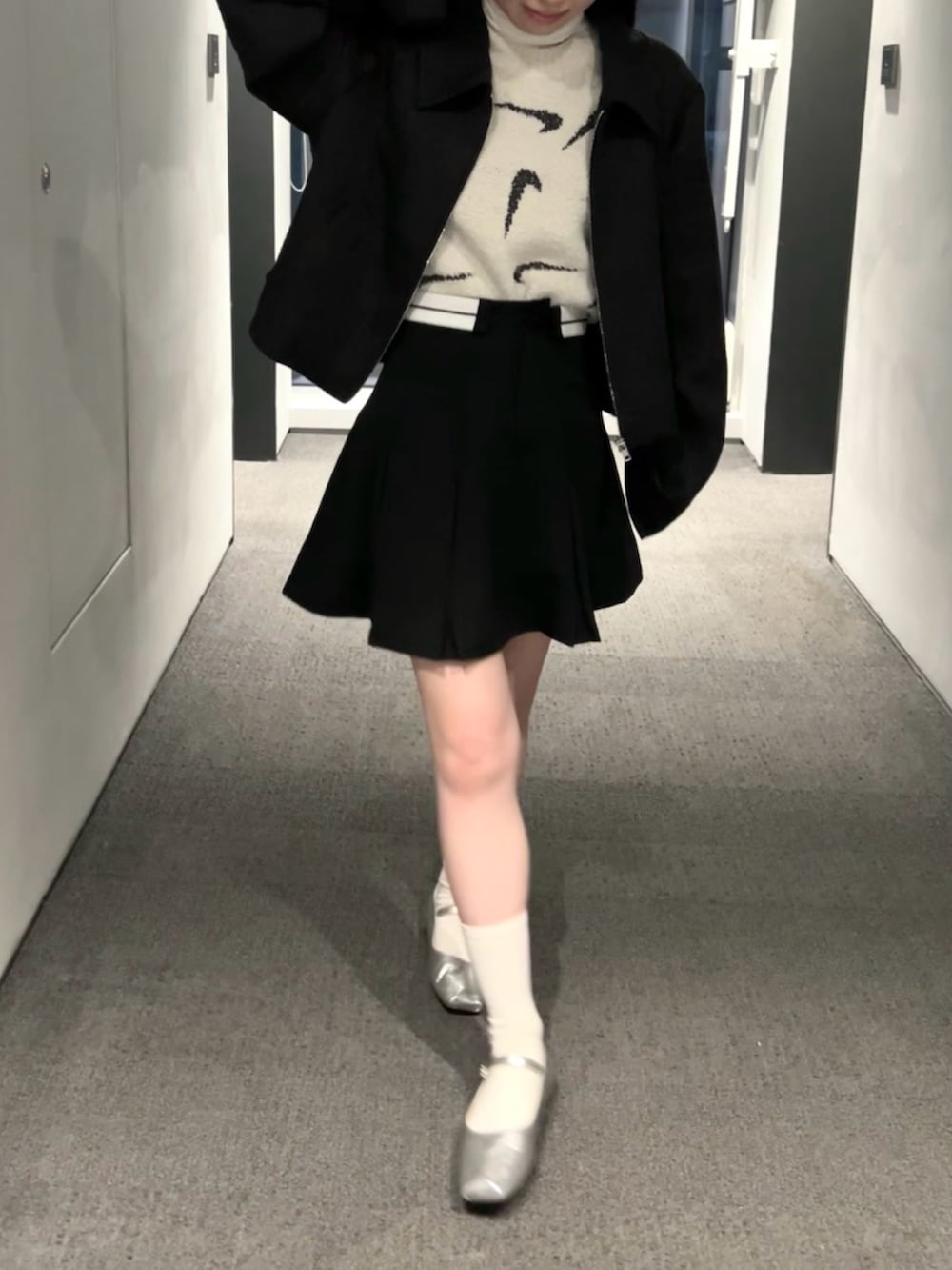 ブラック系のスカート、ブラック系のブルゾン、ブラウン系のTシャツ/カットソーを着用したレディースの春コーディネートの3枚目の写真