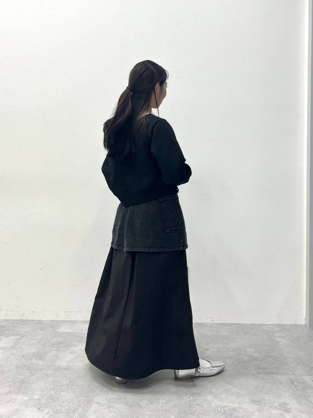 ブラック系のスカート、ブラック系のデニムパンツを着用したレディースの春コーディネートの4枚目の写真