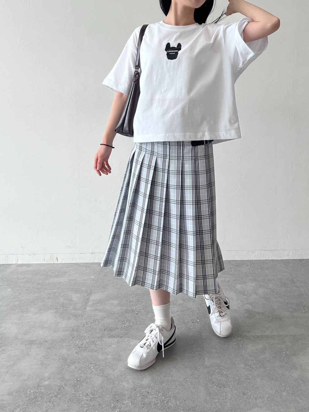 ブルー系のスカート、ホワイト系のTシャツ/カットソーを着用したレディースの夏コーディネートの2枚目の写真