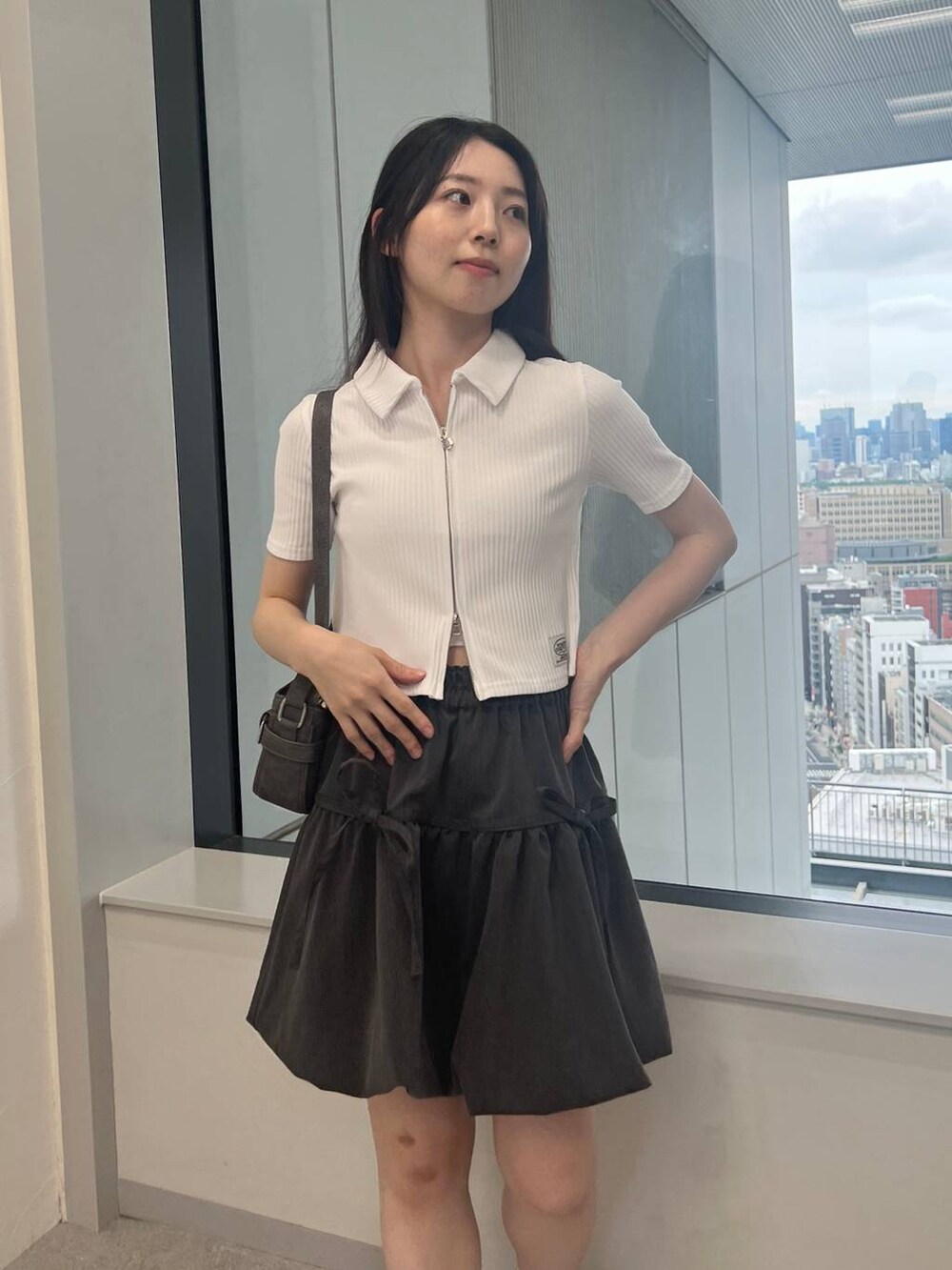 グレー系のスカート、ブラック系のトートバッグ、ホワイト系のカーディガン/ボレロを着用したレディースの夏コーディネートの5枚目の写真