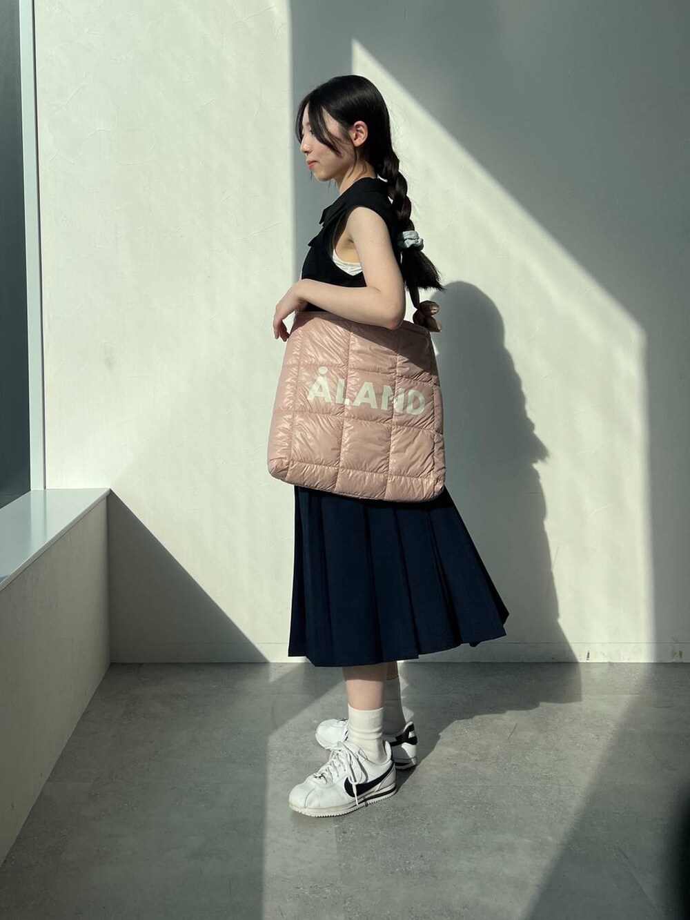 ブルー系のスカート、ピンク系のショルダーバッグ、ブラック系のタンクトップを着用したレディースの夏コーディネートの5枚目の写真