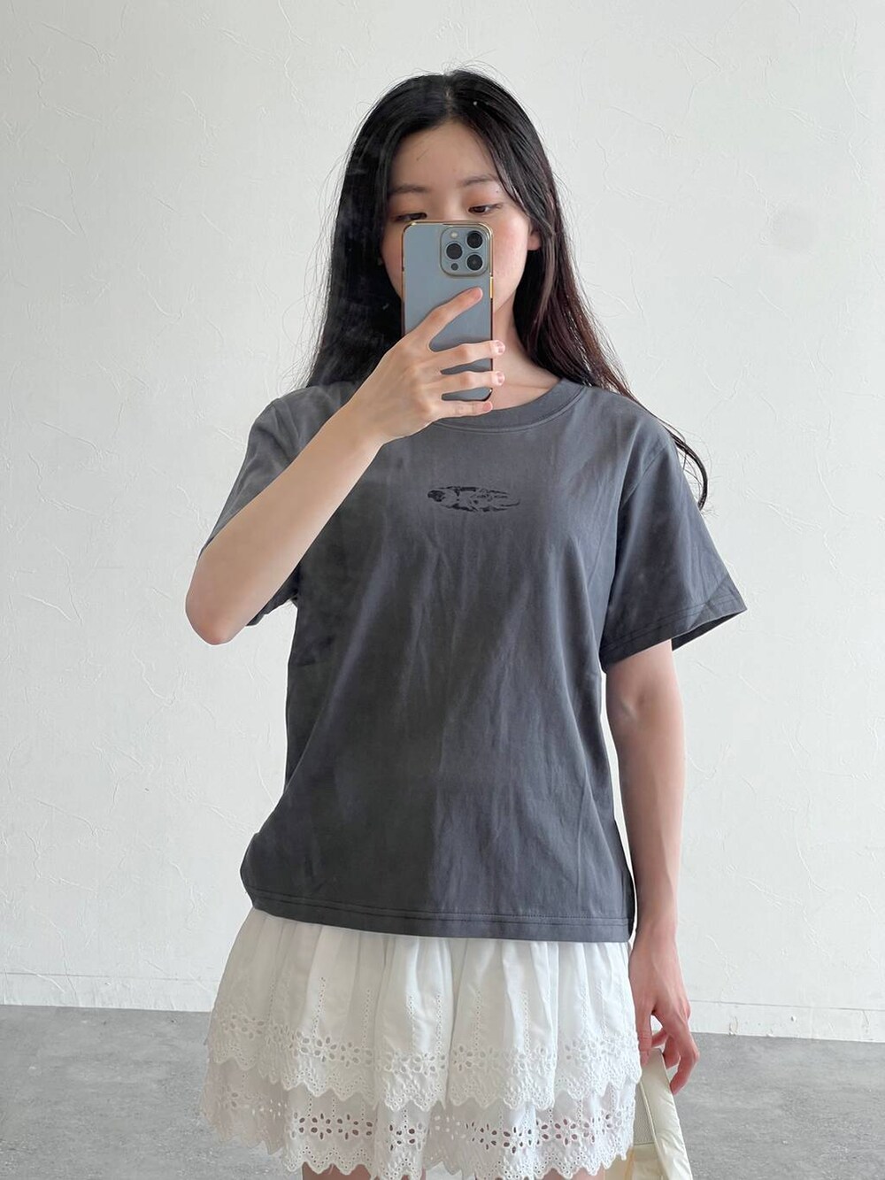 ホワイト系のスカート、ホワイト系のボストンバッグ、グレー系のTシャツ/カットソーを着用したレディースの夏コーディネートの4枚目の写真