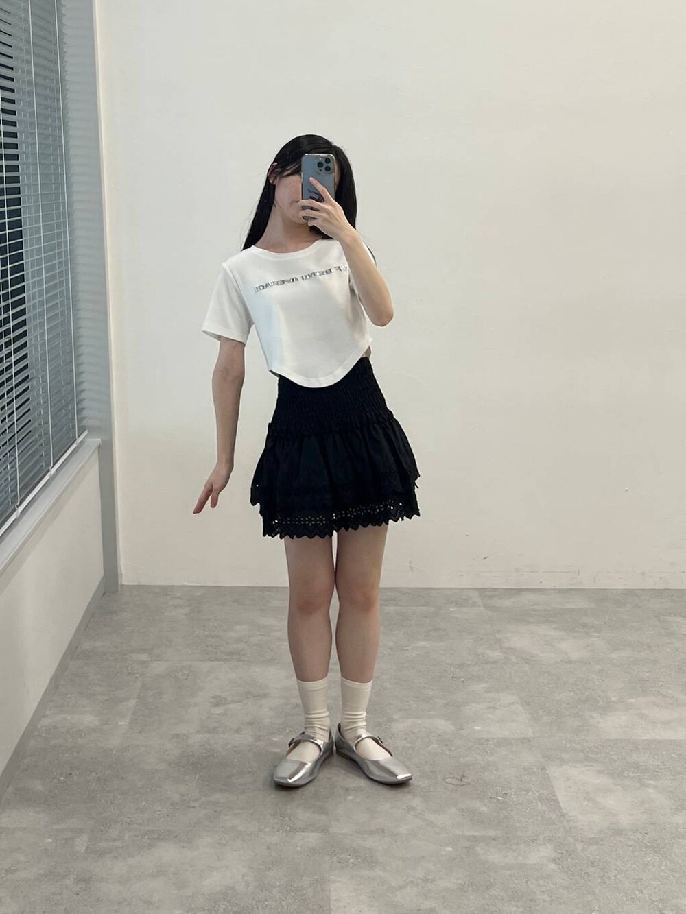 ブラック系のスカート、ホワイト系のTシャツ/カットソーを着用したレディースの春コーディネートの2枚目の写真