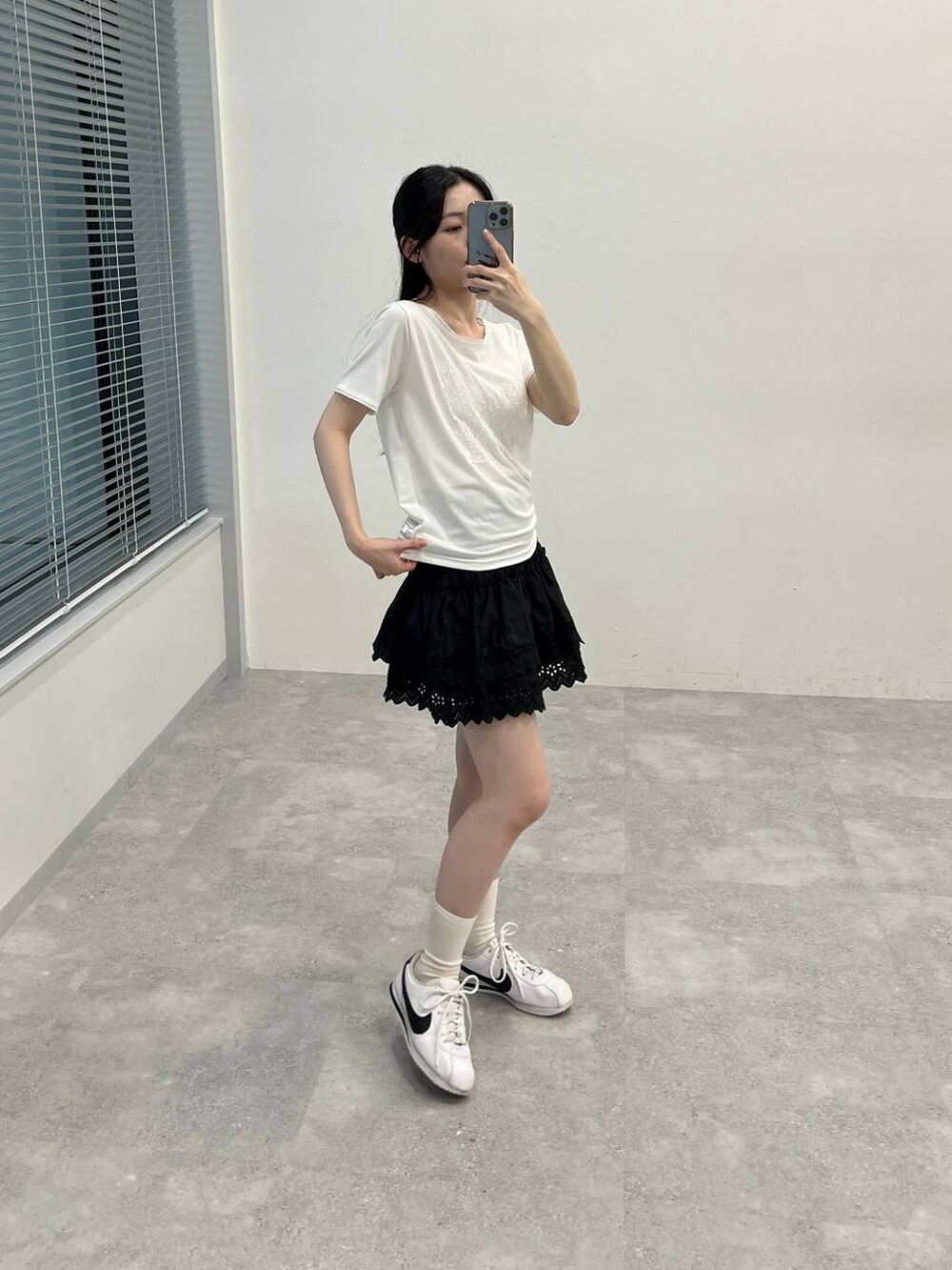 ブラック系のスカート、ホワイト系のTシャツ/カットソーを着用したレディースの夏コーディネートの3枚目の写真