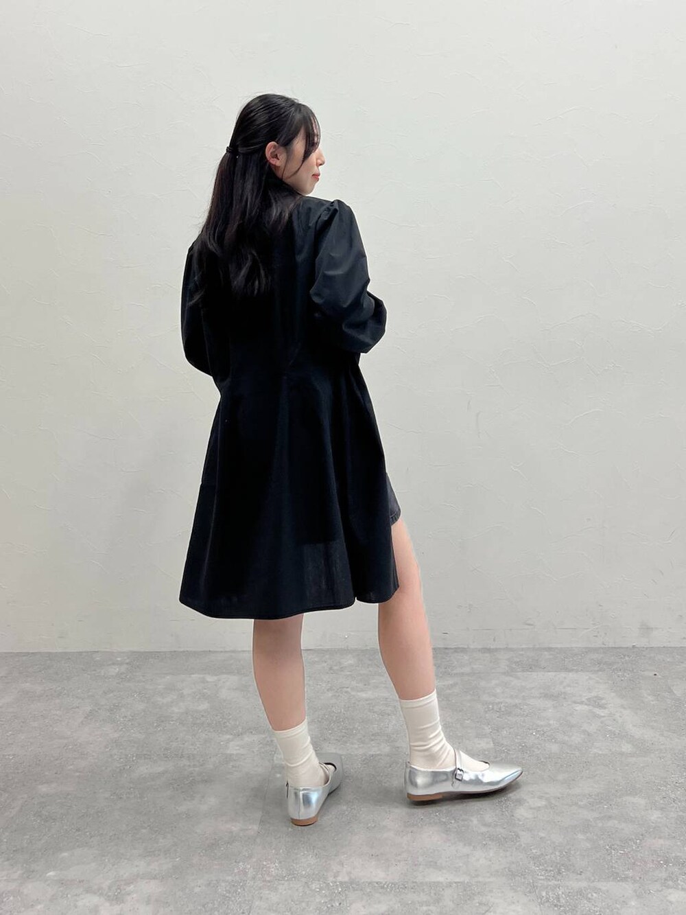 ホワイト系のTシャツ/カットソー、ブラック系のデニムスカート、ブラック系のワンピースを着用したレディースの春コーディネートの3枚目の写真